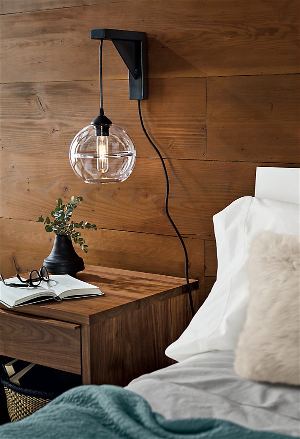Detail of Tandem wall sconce in natural steel in bedroom.